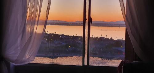 a view of the ocean from a window with the sunset at Albatros Nes 49 Van Spilberg Road Saldanha in Saldanha