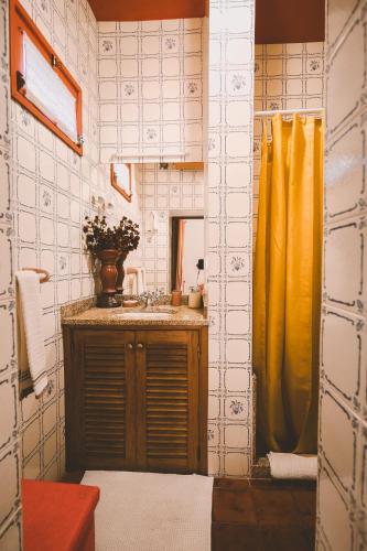 a bathroom with a sink and a yellow shower curtain at Casa Dos Varais, Manor House in Lamego