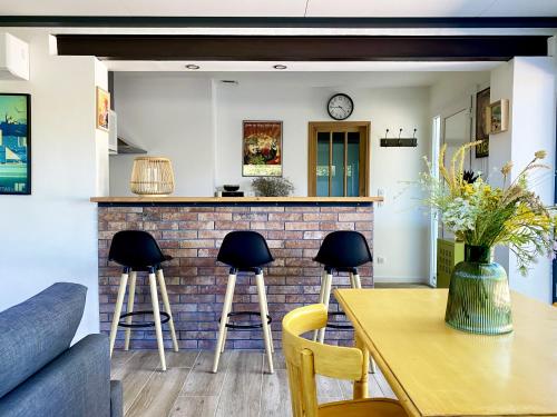 - une cuisine avec une table et un bar avec tabourets dans l'établissement Maisonnette au cœur des Alpilles, à Mouriès