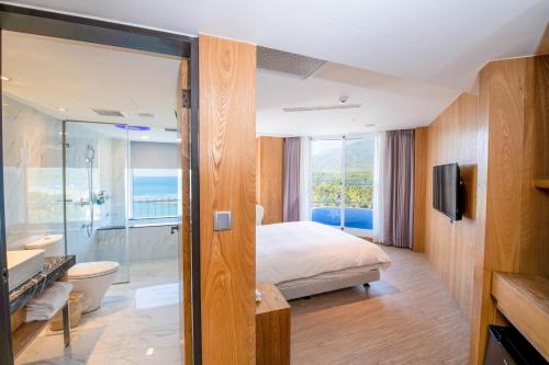 a hotel room with a bed and a bathroom at Kenting Long Beach Hotel in Checheng