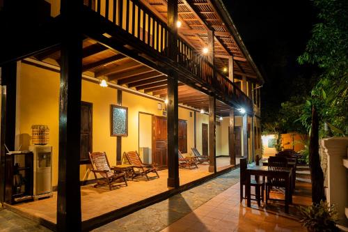 an outdoor patio with chairs and tables at night at Villa Khoum Xieng Thong Boutique in Luang Prabang