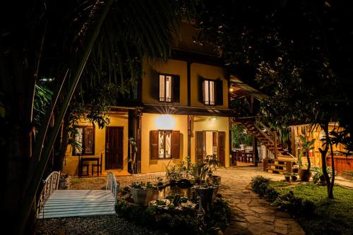 a house at night with a lot of plants at Villa Khoum Xieng Thong Boutique in Luang Prabang