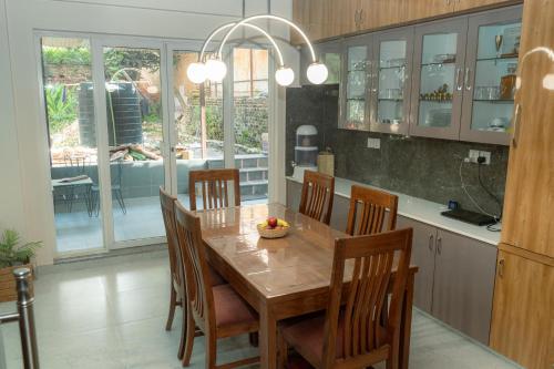 a kitchen with a wooden dining table and chairs at Maitreya Homestay in Pātan