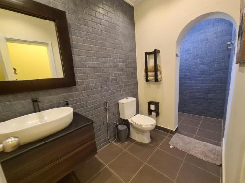 a bathroom with a sink and a toilet and a mirror at Luxury holiday villas in Bahrain for Families in Bārbār