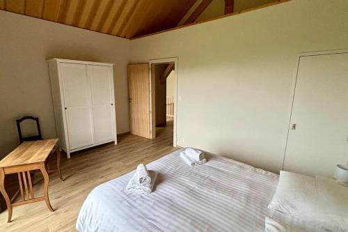 a bedroom with a bed and a table in it at Magnifique villa d'architecte vue sur le lac Léman in Anthy