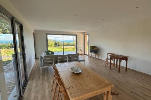 a living room with a table and a couch at Magnifique villa d'architecte vue sur le lac Léman in Anthy