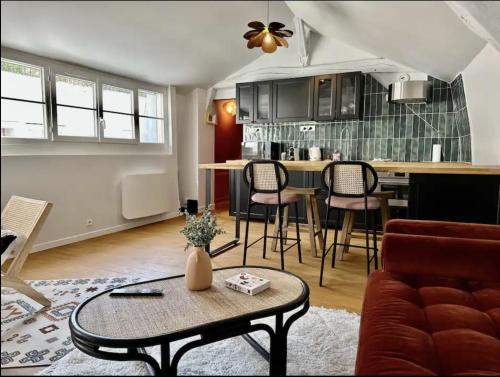 un salon avec une table et une cuisine dans l'établissement Eucalyptus - Reims, à Reims