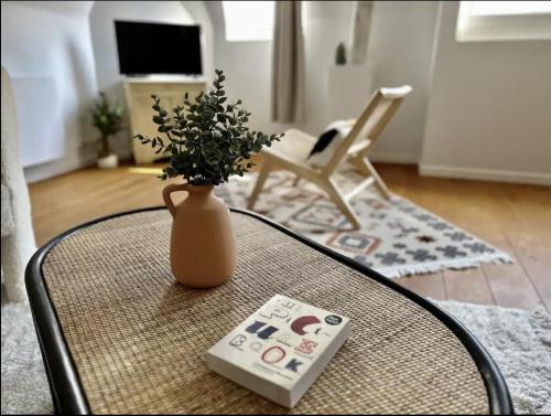 un vase assis sur une table avec télécommande dans l'établissement Eucalyptus - Reims, à Reims