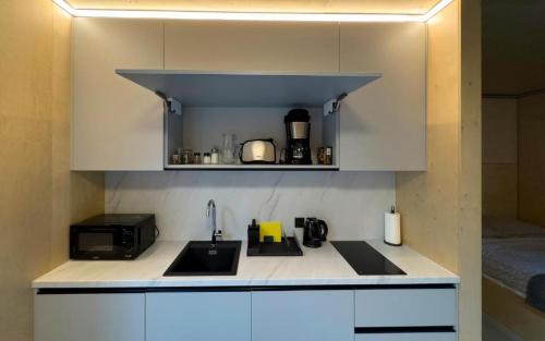 a kitchen with a sink and a microwave at Mountain Cabin by the river - Base Camp Medvědín in Špindlerův Mlýn