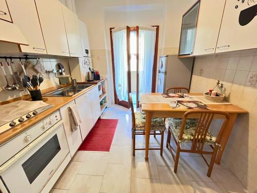 a kitchen with a wooden table and a dining room at La casa di Bianca - Casa Vacanze in Villa Opicina