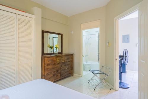 a bedroom with a bed and a mirror and a bathroom at Musgrave AnneX- comfy 1 bedroom apartments in Kingston