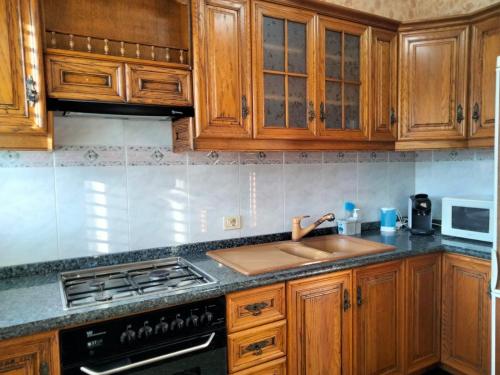 a kitchen with wooden cabinets and a sink at APARTAMENTOS La PEÑA D in La Guancha