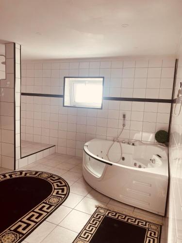 a white tub in a bathroom with a window at Appartement Sabrina in Steinberg am Rofan