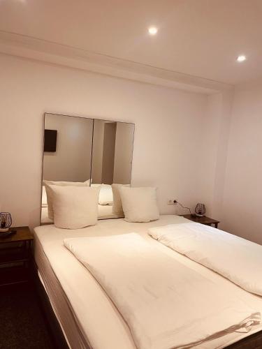 a large white bed with white sheets and pillows at Appartement Sabrina in Steinberg am Rofan