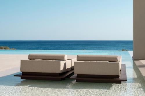 two boxes sitting on the beach near the ocean at POEMO VILLAS in Ierápetra