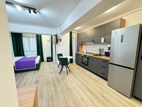 a kitchen with a refrigerator and a bed in a room at Luxury Studios at Unique opposite Palas with Parking in Iaşi