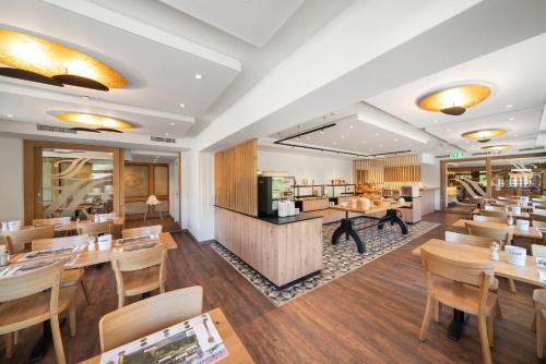 a restaurant with wooden tables and wooden chairs at Jungfrau Lodge, Swiss Mountain Hotel in Grindelwald