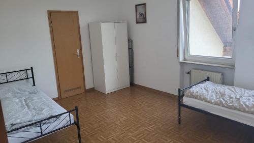an empty room with two beds and a window at Graf Kuno Unterkünfte in Bruchsal