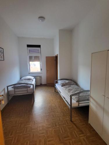 a room with two beds and a window at Graf Kuno Unterkünfte in Bruchsal