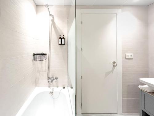 a white bathroom with a shower and a sink at Diyenn Burriana alojamiento y placer in Burriana