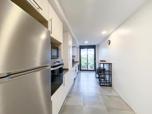 a kitchen with a stainless steel refrigerator and white walls at Diyenn Burriana alojamiento y placer in Burriana