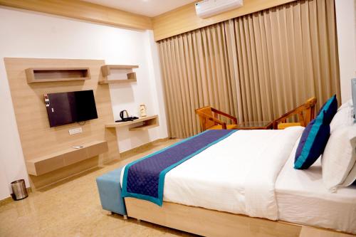 a bedroom with a large bed and a tv at Hotel The Urban Dream in Udaipur