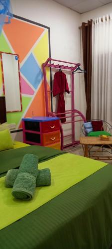 a bedroom with two green beds and a colorful wall at Elena Garden Resort and Restaurant in Trincomalee
