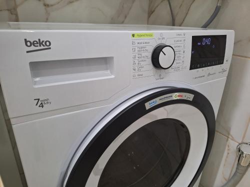 a white washing machine sitting in a room at Relax Lux apartment Nis in Niš