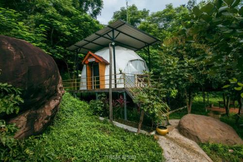 a small house with a balcony in a forest at Thisak Resort Cheung phnom kulen in Siem Reap