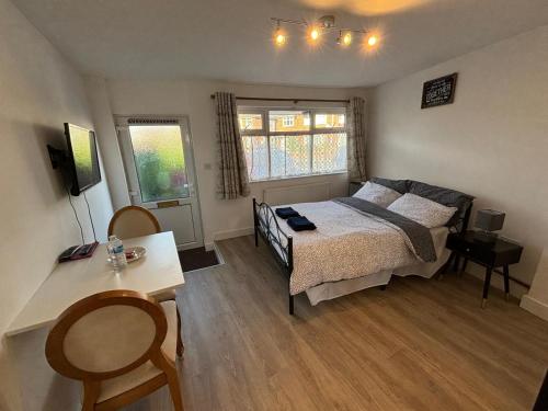 a bedroom with a bed and a table and two windows at Modern & Cozy Gem - 10min to City Center - Parking in York