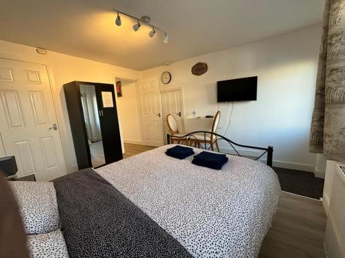 a bedroom with a bed and a table and a television at Modern & Cozy Gem - 10min to City Center - Parking in York