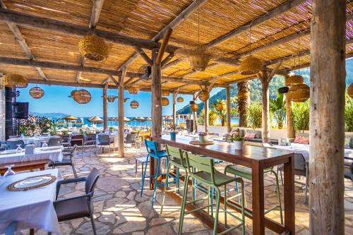 a restaurant with tables and chairs on the beach at Hotel Ekincik in Ekincik
