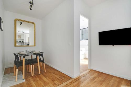 une salle à manger avec une table et une télévision dans l'établissement Charming apartment -1BR-4P- Gare Montparnasse, à Paris