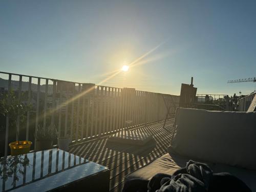 a sun shining on a deck with a chair and a table at Zürich 3 Zimmer Wohnung mit Dachterrasse in Zürich