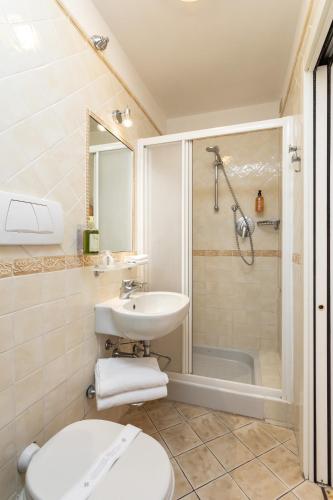 a bathroom with a toilet and a sink and a shower at Hotel Minerva in Siena