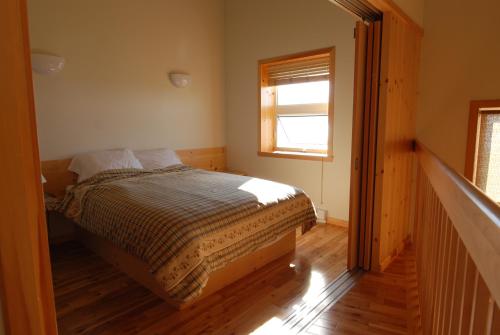 a bedroom with a bed and a window at Les Chalets du Bioparc in Bonaventure