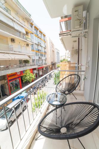 a balcony with two chairs and a table on it at VersusArtSuites in Serres