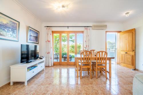 a living room with a table and chairs and a television at Que Bo in Alcudia