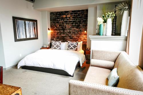 a bedroom with a bed and a brick wall at Blue on Water in St. John's