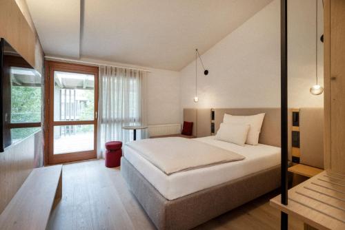 a bedroom with a white bed and a window at Heilthermen Resort Bad Waltersdorf in Bad Waltersdorf