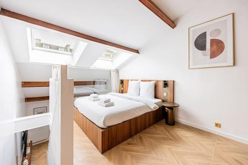 Cette chambre comprend un lit avec des draps blancs et du parquet. dans l'établissement 155#Suite luxueuse#Etienne Marcel#Châtelet#Paris 3, à Paris