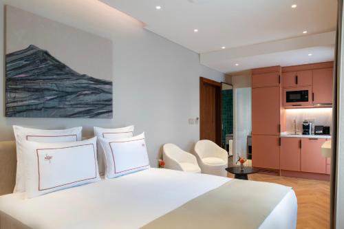a bedroom with a white bed and a kitchen at Casa Foscolo Hotel, Istanbul, a Member of Design Hotels in Istanbul