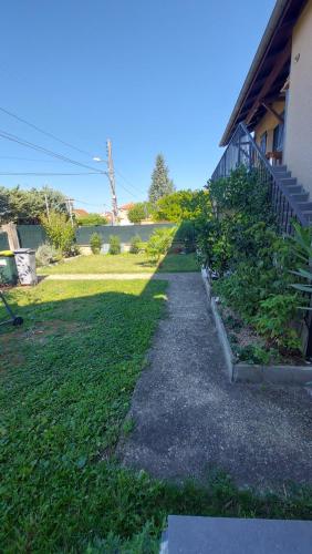 a walkway next to a house with a yard at K&N - Maison à partager avec d'autres voyageurs - Chambre privée - Jardin - Balcon in Vaulx-en-Velin