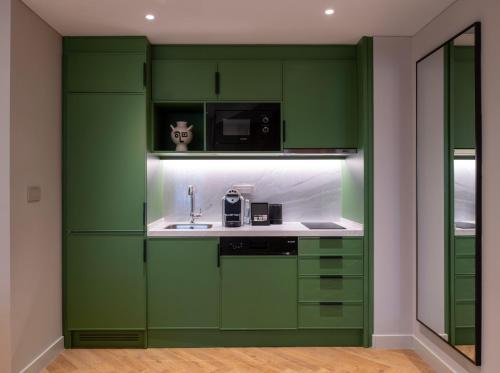 a kitchen with green cabinets and a sink at Casa Foscolo Hotel, Istanbul, a Member of Design Hotels in Istanbul