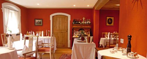 a dining room with white tables and a red wall at Romantik Hotel Zum Klosterbräu in Neuburg an der Donau