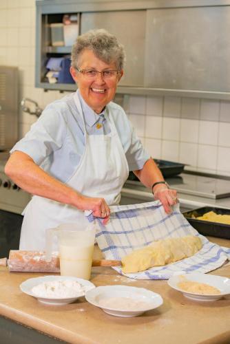 a man standing in a kitchen preparing food at Romantik Hotel Zum Klosterbräu in Neuburg an der Donau