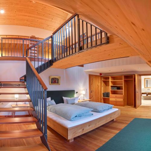 a bedroom with a bed under a staircase at Romantik Hotel Zum Klosterbräu in Neuburg an der Donau