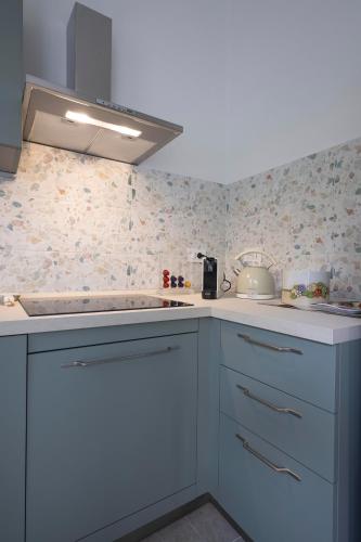 a kitchen with blue cabinets and floral wallpaper at MyVilla - Ivrea via Rosselli 9 in Ivrea