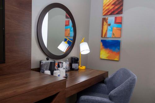 a bathroom with a vanity with a mirror and a chair at Hampton Inn & Suites Riverton in Riverton