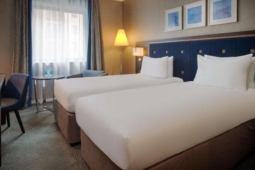 a hotel room with a large bed and a desk at DoubleTree by Hilton Woking in Woking